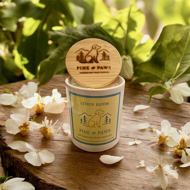 Natural scented candle with wooden lid on rustic wooden surface.